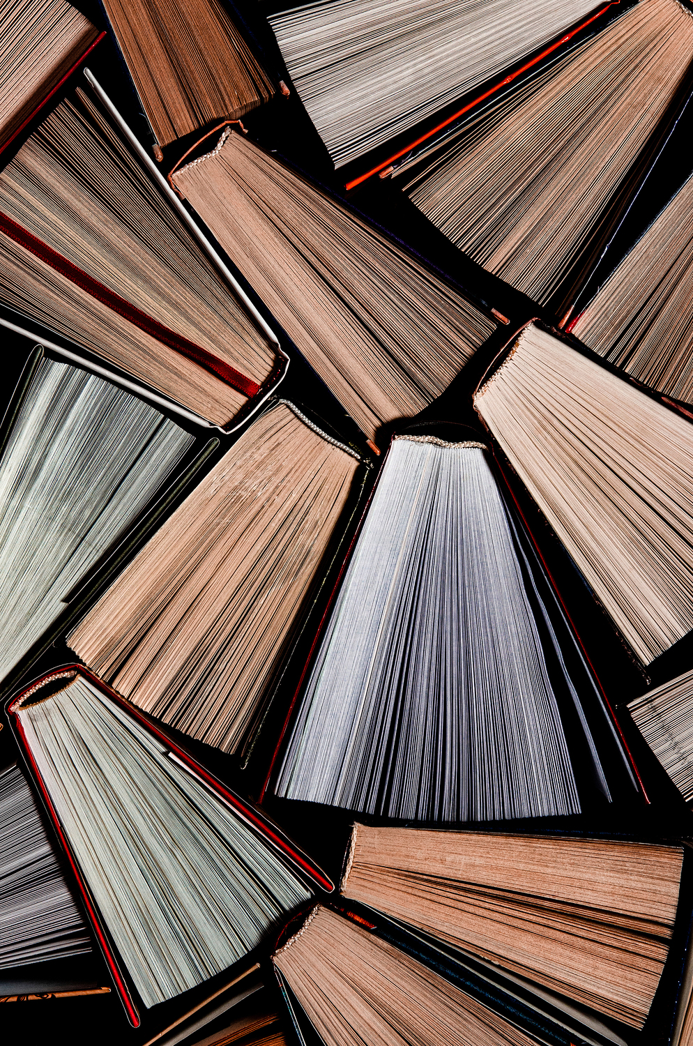 Books. Lots of colourful thick open books stand on a dark background. ready to read